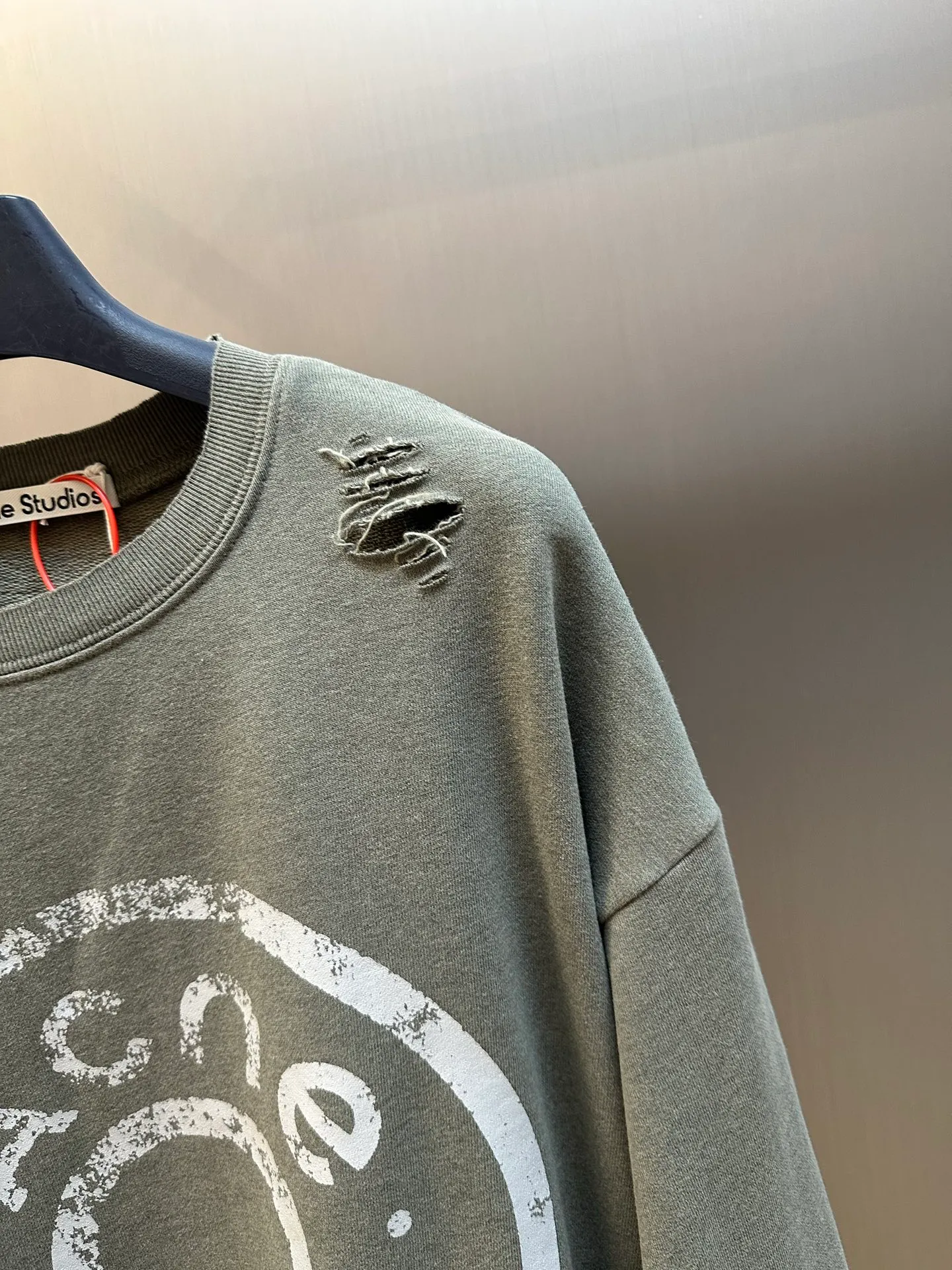 Ac Studios ripped distressed logo sweatshirt, custom dyed 1:1 gray green soft cotton sweatshirt material, the top fabric and terry bottom are the same color configuration, the market fabric In Stock has a different color on the top and bottom, which does not match the original! The minimum order quantity of fabric is 2 tons, and the fabric manufacturing process alone takes 45 days! The unruly soul of Ac Studios is engraved on the chest. The ingenious integration of hole elements and wanton swaying on the Gray canvas is a deliberate rebellion and a break away from the shackles of tradition. It is unique in the wave of the trend. It uses glue printing. The chest printing has been modified three times with the film screen. The glue liquid paint is used to print the pattern on the fabric, and the fabric is baked to fix the printing pattern. Many parts of the body of the garment are frayed and worn at regular intervals by purely artificial means, and marks are manually brushed to add texture and depth to the surface of the garment to imitate the texture of natural wear and tear. size：s m l xl